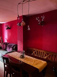 a dining room with red walls and a table with chairs at Casa Camas, wide 2bedroom, feel the mountain in Breuil-Cervinia