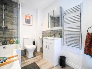 a white bathroom with a toilet and a sink at Golden King Suite - Balcony & FREE Parking - Central Bedford in Bedford