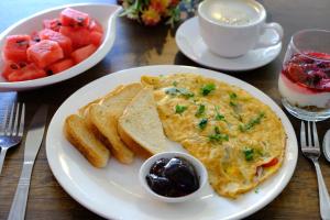 een bord ontbijtproducten met omelet en toast bij Victoria City Hotel in Oranjestad