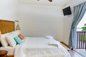 a bedroom with a white bed and a balcony at Aaki Hotel in Las Peñitas