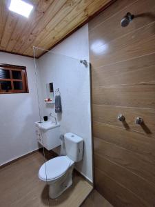 a bathroom with a toilet and a shower at Pousada Lofts e Suítes Campos in Campos do Jordão