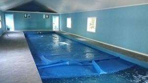 an indoor swimming pool in a room with blue walls at Cabañas Ruta Del Lago in Puerto Varas
