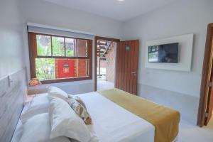 a bedroom with a large bed and a window at Pousada do Rosa Camburi in Camburi