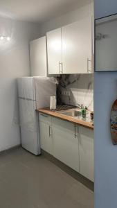 uma cozinha branca com um lavatório e um frigorífico em Casa Vive em Puerto de la Cruz