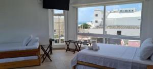 1 dormitorio con 2 camas y ventana grande en Santa Julia Travel, en San Andrés
