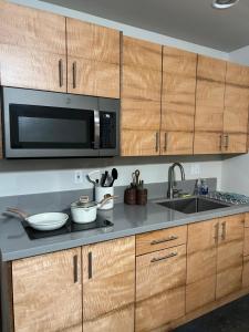 a kitchen with wooden cabinets and a microwave at Private Ohana on the lush Hamakua coast with AC in Honokaa