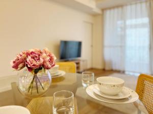 a glass table with a vase with a flower in it at Mascot Cozy Apartment + Free Parking in Sydney