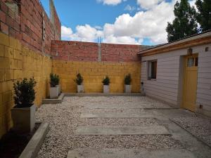 a garage with a yellow door next to a brick wall at Casa Grilli cerca de la terminal in Río Gallegos