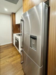 a stainless steel refrigerator in a kitchen at Mascot Cozy Apartment + Free Parking in Sydney