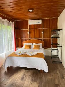 a bedroom with a large bed with wooden walls at Gambas Lodge in Fortuna