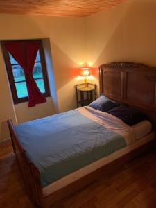 a bedroom with a bed with a lamp and a window at Lieu dit le jardin in Saint-Lambert
