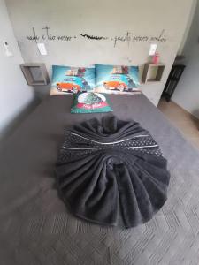 um quarto com um cobertor preto numa cama em Mini Casa Chácara Zulin's - AMOR E ACONCHEGO em Pontal do Paraná
