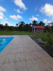a swimming pool with a house in the background at Mini Casa Chácara Zulin's - AMOR E ACONCHEGO in Pontal do Paraná