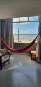 a hammock in a room with a view of the beach at Sinta-se no mar da sala d'estar in Praia Grande
