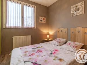 - une chambre dotée d'un lit avec un couvre-lit floral dans l'établissement Gîte Chemillé-en-Anjou-Chemillé-Melay, 4 pièces, 6 personnes - FR-1-622-11, à Saint-Georges-du-Puy-de-la-Garde