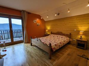 a bedroom with a bed and a large window at Chalet 3 étoiles avec sauna près de La Bresse - FR-1-589-18 in Basse-sur-le-Rupt