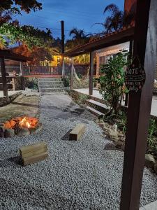 un patio trasero con una hoguera y una casa en Recanto do Pajé, en Praia do Rosa