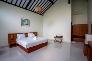 RaCottage Mandalika في كوتا لومبوك: غرفة نوم بسرير ومغسلة في غرفة