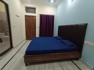a bedroom with a bed with a blue blanket at Deepak Homestay in Rishīkesh