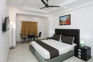 a bedroom with a large bed and a table with chairs at Collection O Hotel Residency Near Dwarka Sector 21 Metro Station in New Delhi