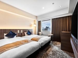 ein Hotelzimmer mit 2 Betten und einem TV in der Unterkunft DEL style Osaka-Shinsaibashi by Daiwa Roynet Hotel in Osaka