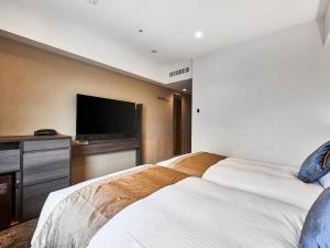 大阪的住宿－DEL style Osaka-Shinsaibashi by Daiwa Roynet Hotel，酒店客房设有两张床和一台平面电视。