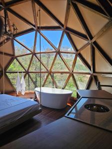 Habitación con ventana y baño con bañera. en Domo Vila da Serra, en Nova Lima