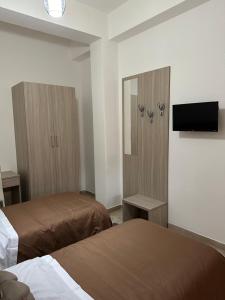 a hotel room with two beds and a flat screen tv at B&B Rosario in Gioia Tauro