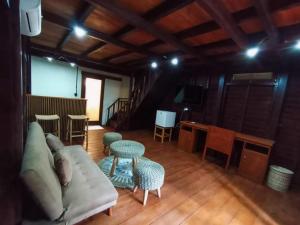 a living room with a couch and a table and chairs at RaCottage Mandalika in Kuta Lombok