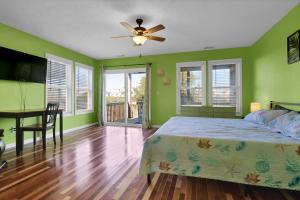 um quarto com paredes verdes, uma cama e uma mesa em 421-a N New River Drive em Surf City