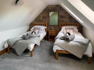 two beds with dolls on them in a attic at West View Cottage in Seahouses