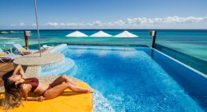 una mujer en el borde de una piscina en The Carmen Hotel - Ocean Front, en Playa del Carmen