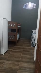 een kamer met een koelkast en een tegelvloer bij Cantinho do Sossego - kitnets in Cananéia
