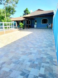 a patio in front of a blue house at casa do serramar in Rio das Ostras