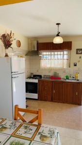 une cuisine avec un réfrigérateur blanc et une table dans l'établissement SanVitto, à Las Grutas