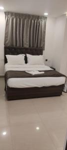 a bedroom with a large bed with white pillows at Earth Inn in Chennai