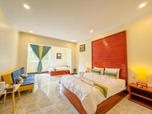 a large bedroom with a large bed and a chair at Summer Resort in Kep