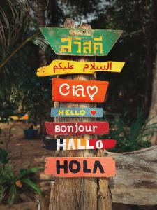 a sign on a wooden post with different languages at Simple Life Bungalows in Ko Jum
