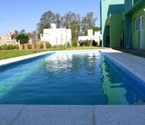 a swimming pool with blue water in front of a house at La Francisca in Almafuerte