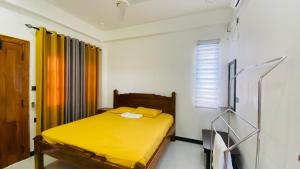 een slaapkamer met een geel bed en een raam bij villa24.trinco in Trincomalee