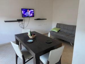 a dining room with a black table and white chairs at La Mía Casa Playa Union in Playa Unión