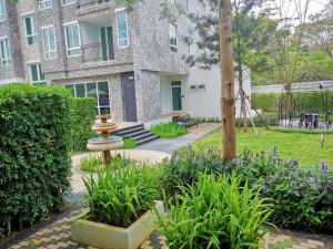 a garden with a fountain in front of a building at Courtyard Khaoyai By SW in Mu Si