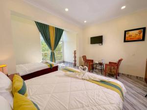 a hotel room with two beds and a window at Summer Resort in Kep