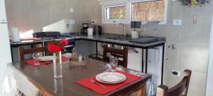 cocina con mesa con servilletas rojas y encimera en CASITA DE ANELÉ en San Carlos de Bariloche