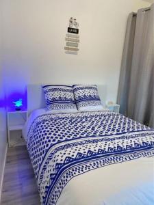 1 dormitorio con 1 cama con edredón azul y blanco en Appartement chaleureux à Alfortville, en Alfortville