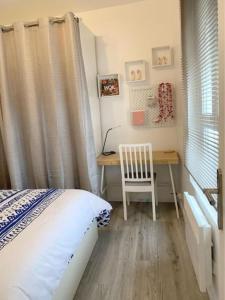 a bedroom with a desk with a bed and a chair at Appartement chaleureux à Alfortville in Alfortville