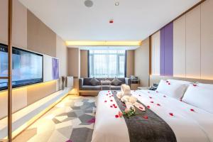 una habitación de hotel con una cama grande con rosas. en Lavande Hotel Chaoshan International Airport, en Chaozhou