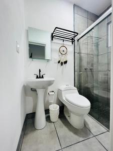 a bathroom with a toilet and a sink and a shower at Casa Ambar in Tijuana