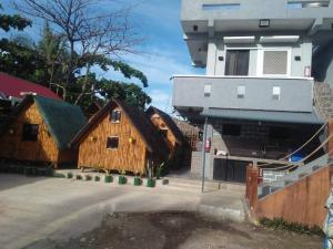 a group of wooden buildings in front of a building at Kua's Pad Batangas Tent in Calatagan
