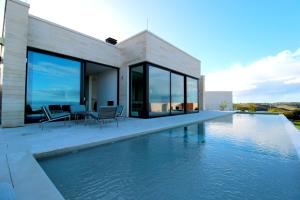une maison avec une piscine à côté d'une maison dans l'établissement Deluxe Villa Jante Infinity Pool, à Durrës